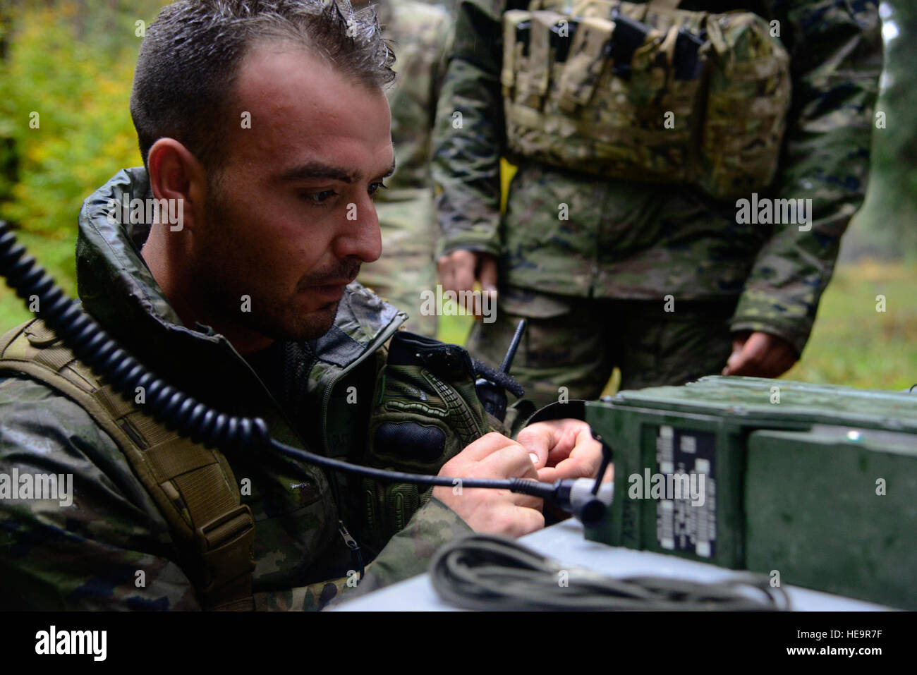 A Spanish soldiers assists with constructing a Field Expedient Antenna as part of the European
