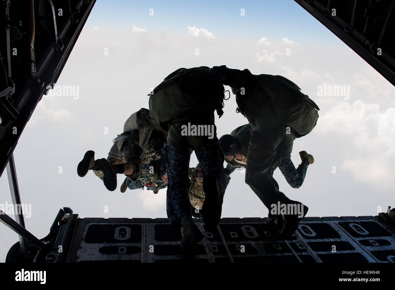 U.S. and Thai air forces conduct a High Altitude Low Opening jump from a U.S. C-130 during Exercise Cope Tiger 15 near Udon, Thailand, March 11, 2015. CT15 includes 22 total flying units and over 1,390 personnel from three countries and continues the growth of strong, interoperable and beneficial relationships within the Asia-Pacific region through integration of airborne and land-based command and control assets.  Airman 1st Class Taylor Queen Stock Photo