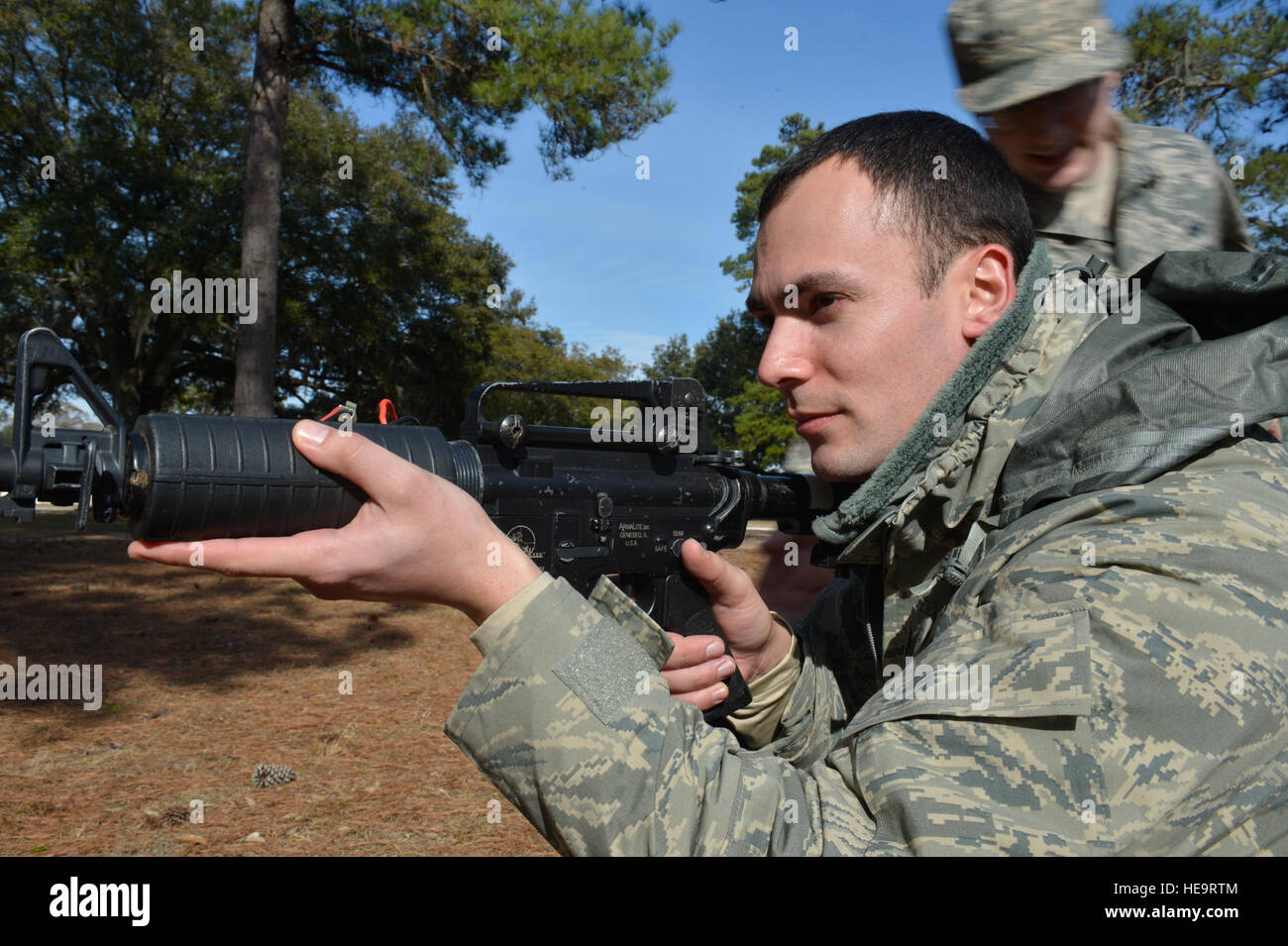U.S. Air Force Tech. Sgt. Jason Kilanski, 1st Combat Camera Squadron combat broadcaster, provides security for his team to cross over a road during Exercise Scorpion Lens 15, Joint Base Charleston, S.C., Feb. 4, 2015. Exercise Scorpion Lens 2015 is an annual exercise designed to validate the ability of Air Force Combat Camera Airmen to survive, operate, and provide directed imagery capability in an austere environment including in the presence of chemical, biological, radiological, and nuclear contamination. Combat Camera Airmen document a full range of military operations in support of senior Stock Photo