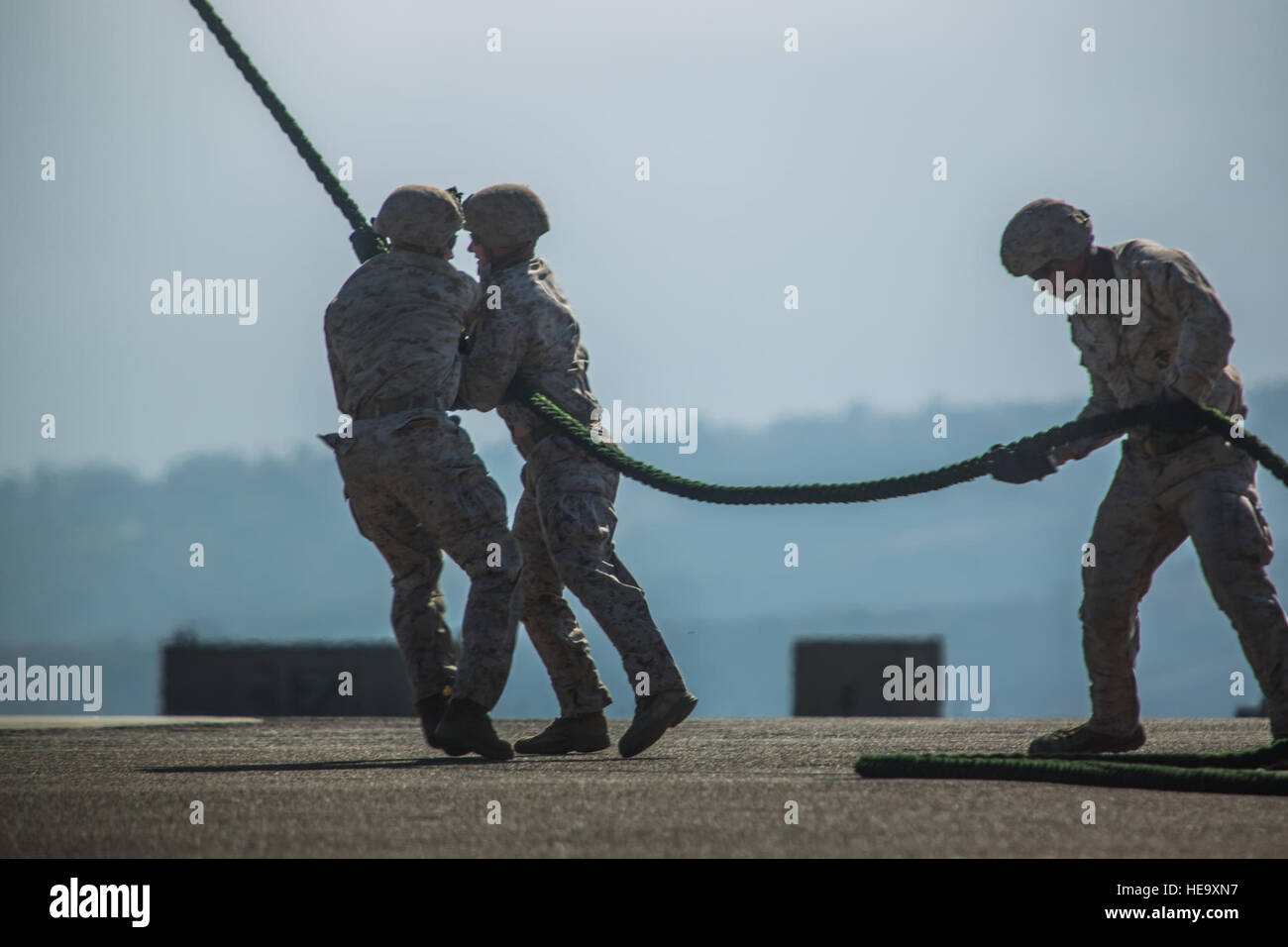 Marines with 2nd Battalion, 5th Marine Regiment, Weapons Company, Scout Sniper Platoon, prevent a rope from flailing in the rotor wash of an MV-22B Osprey with Marine Medium Tiltrotor Squadron 164 during fast-rope training aboard Marine Corps Base Camp Pendleton, Calif., June 30. The ability to fast rope enables Marines to insert into an area or structure without landing the aircraft, eliminating the need for a landing zone.  Sgt. Lillian Stephens Stock Photo