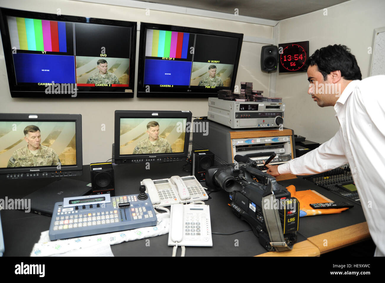 Farid Ullah, British Broadcasting Company satellite engineer, right, checks system and equipment settings in the gallery of British Broadcasting Company studios in Kabul, Afghanistan, July 29, 2011, prior to a satellite interview of Lt. Gen. William B. Caldwell, IV, by Zeinab Badawi, BBC television and radio journalist, from London for a segment to air on “Hardtalk.” Ms. Badawi interviewed General Caldwell about the current and future progress of the training mission in Afghanistan and the tentative 2014 coalition to Afghan forces security transition. General Caldwell expressed his confidence  Stock Photo