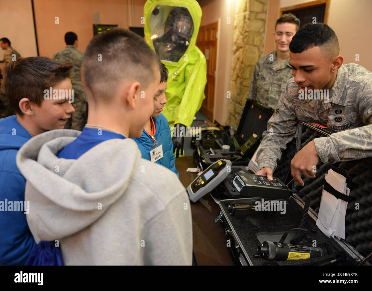 U.S. Air Force Airman 1st Class Christopher Montgomery, 97th Civil Engineer Squadron emergency management technician, explains the purpose and demonstrates the use of a radioactive detection device to children from Will Rogers Elementary School, Burns Flat, Okla., during a Science, Technology, Engineering, and Math fair at Club Altus, Feb. 5, 2015. Altus Air Force Base hosted the STEM fair for approximately 70 students to show how STEM subjects apply to various occupations throughout the base.  Airman 1st Class Megan E. Acs Stock Photo