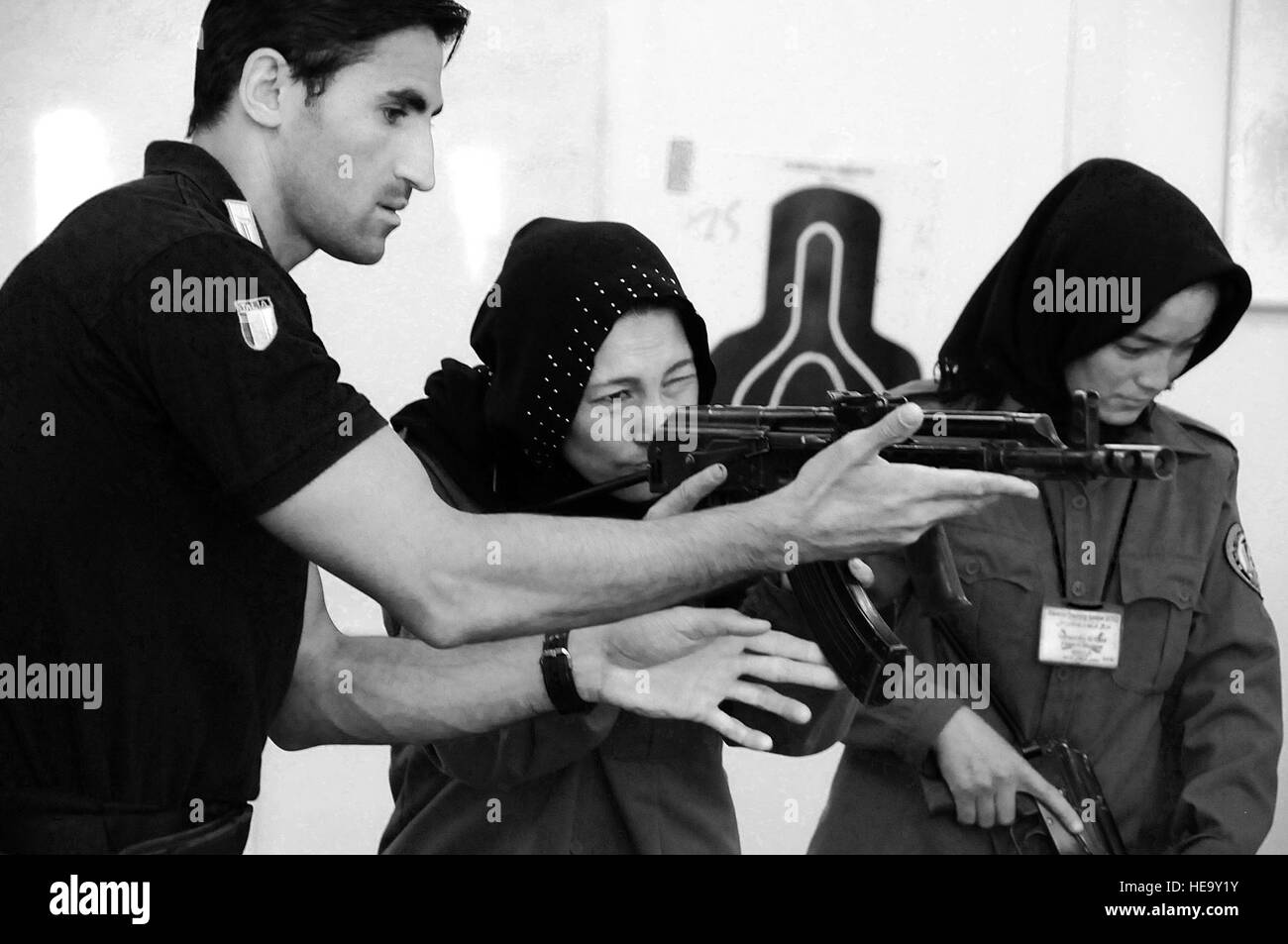 100710-F-1020B-006 copy Kabul - An Italian Carabinieri shows a female Afghan National Police recruit how to aim an AMD-65, a Hungarian version of the AK-47, during an eight-week basic police training course at the Central Training Center in Kabul. Afghan President Hamid Karzai has mandated an additional 5,000 women be added to the ANP by 2014; they are needed to respect cultural norms while providing security.   Staff Sgt. Sarah Brown/) Stock Photo