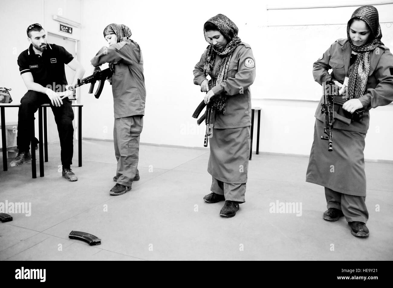 100710-F-1020B-015BW Kabul -  An Italian Carabinieri watches as female Afghan National Police recruits demonstrate how to use an AMD-65, a Hungarian version of the AK-47, during an eight-week basic police training course at the Central Training Center in Kabul. Afghan President Hamid Karzai has mandated an additional 5,000 women be added to the ANP by 2014; they are needed to respect cultural norms while providing security.   Staff Sgt. Sarah Brown/) Stock Photo