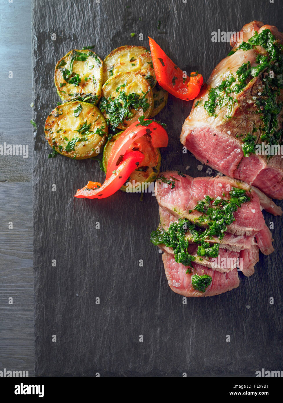 Roast Beef dinner with roasted zucchini, pepper and salsa verde Stock Photo