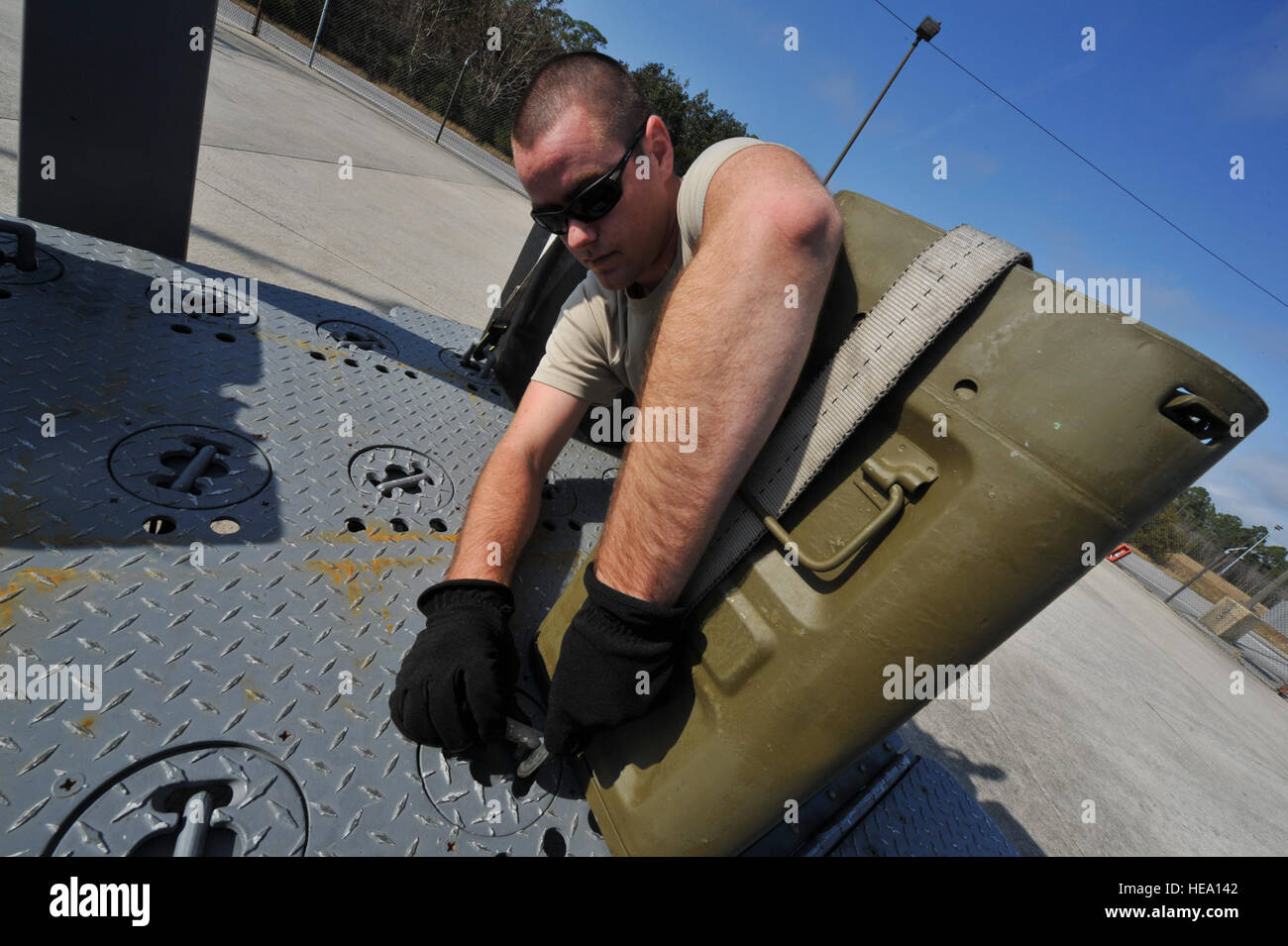 Senior Airman Patrick Beam, 1st Special Operations Equipment Maintenance Squadron munitions line delivery driver, secures a container of 40mm rounds to a munitions trailer on Hurlburt Field, Fla., Dec. 6, 2013. Line delivery drivers Properly secured containers to prevent damage during transport. Staff Sgt. John Bainter) Stock Photo