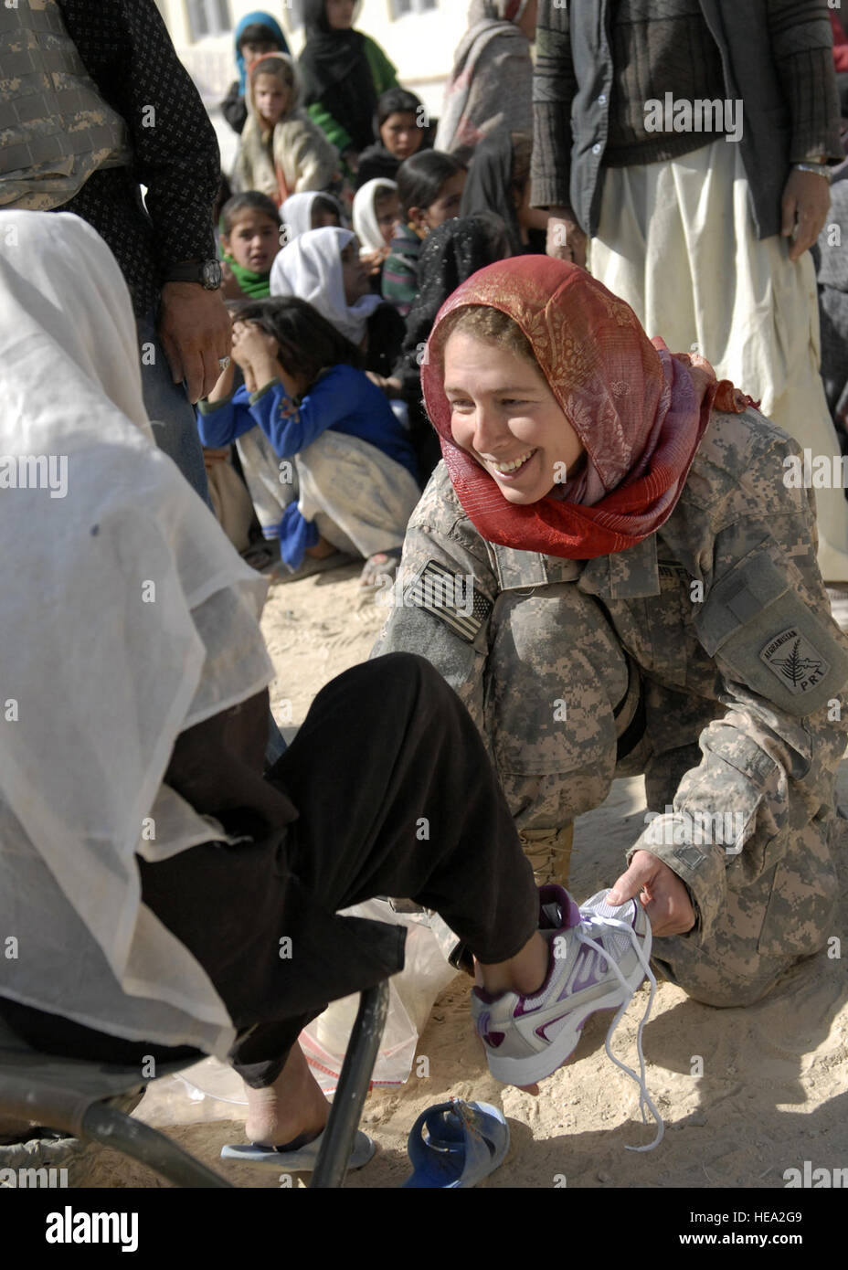 Staff Sgt. Sarah Saelens, a medical technician with Task Force Zabul''s Provincial Reconstruction Team, gives out shoes to orphaned Afghan school children at a shoe drive in Qalat city in southern Afghanistan. Over 500 shoes were privately donated by local charities in Seattle, Wash. Stock Photo