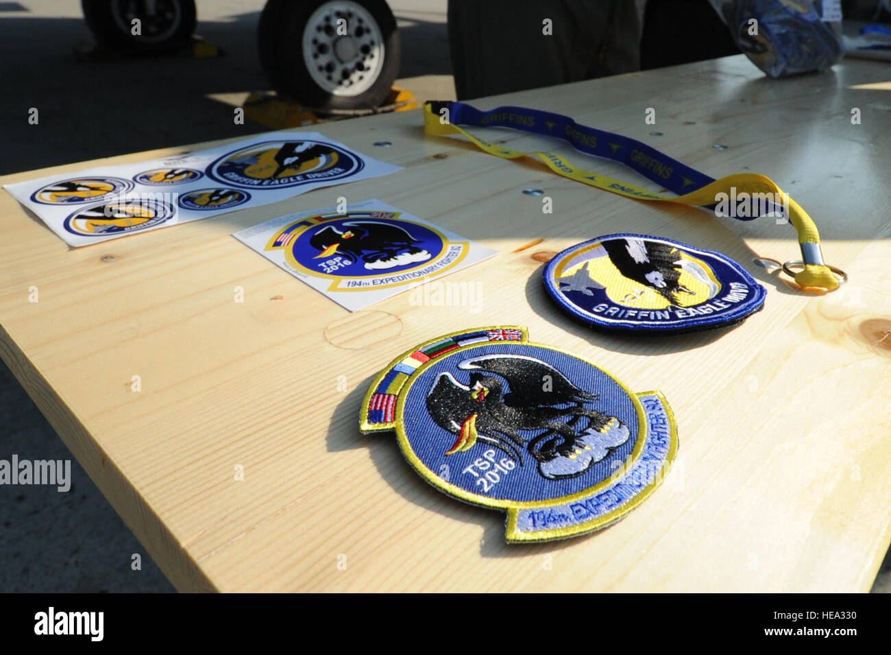 A collection of patches, stickers and lanyards emblazoned with the 194th Expeditionary Fighter Squadron logo rest on a table during the Romanian air force's 71st Air Base's air show and open house at Campia Turzii, Romania, July 23, 2016. The aviation demonstration took place during the middle of the 194th EFS' six-month long theater security package deployment to Europe in support of Operation Atlantic Resolve, which aims to bolster the U.S.'s continued commitment to the collective security of NATO and dedication to the enduring peace and stability in the region. The unit, comprised of more t Stock Photo