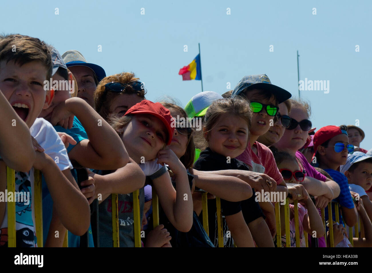 Romanian children watch aircraft take off from the flightline during the Romanian air force's 71st Air Base's air show and open house at Campia Turzii, Romania, July 23, 2016. The aviation demonstration took place during the middle of the U.S. Air Force's 194th Expeditionary Fighter Squadron's six-month long theater security package deployment to Europe in support of Operation Atlantic Resolve, which aims to bolster the U.S.'s continued commitment to the collective security of NATO and dedication to the enduring peace and stability in the region. The unit, comprised of more than 200 CANG Airme Stock Photo