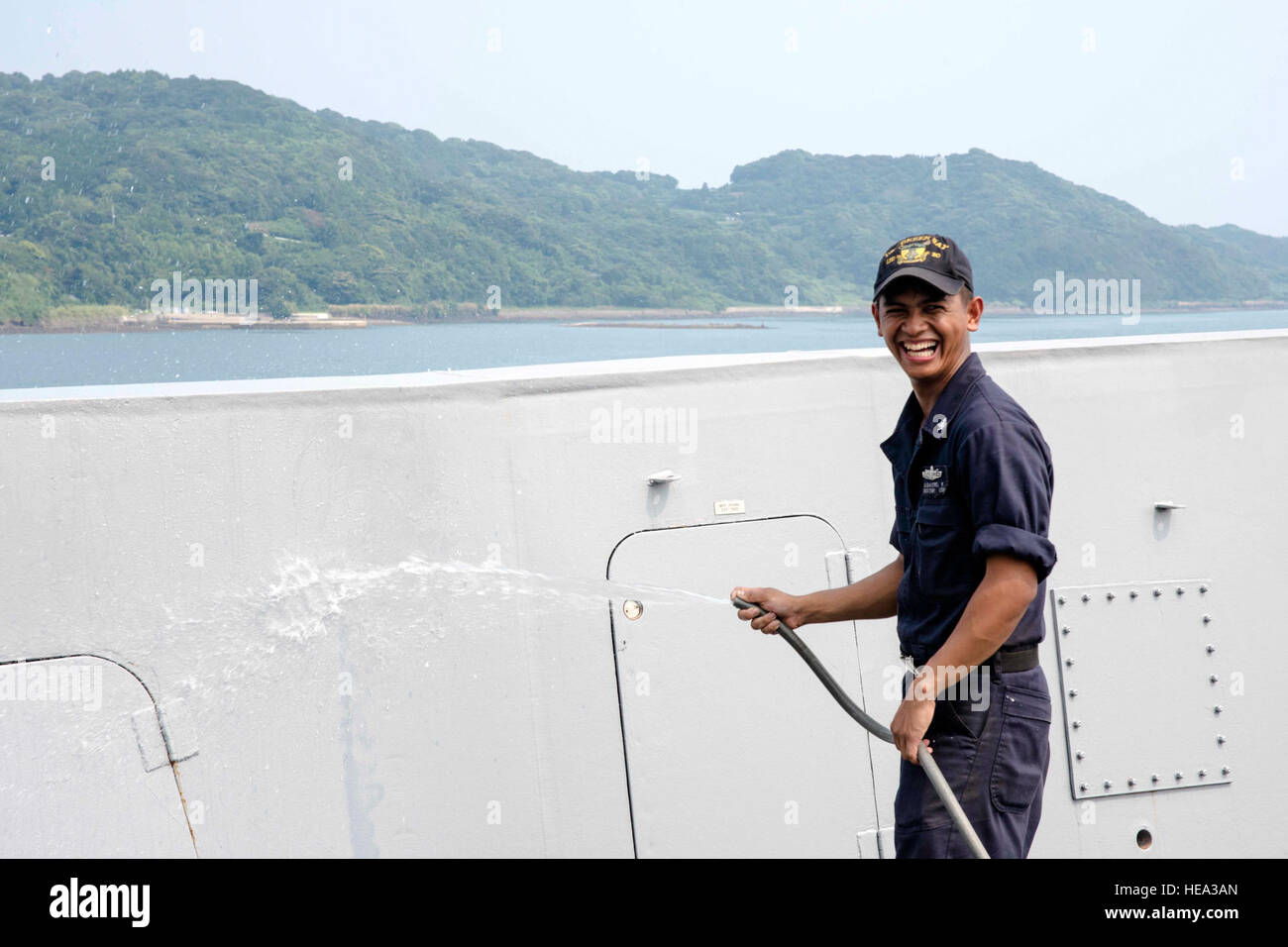 SASEBO, Japan (Aug. 4, 2016) Boatswain’s Mate 3rd Class Kimber Albastro sprays water on the forecastle of the amphibious transport dock ship USS Green Bay (LPD 20) during a freshwater wash-down. Green Bay is attached to the Bonhomme Richard Amphibious Ready Group and is currently underway conducting preparations for an upcoming deployment to the U.S. 7th Fleet area of operations.  Mass Communication Specialist 1st Class Chris Williamson Stock Photo