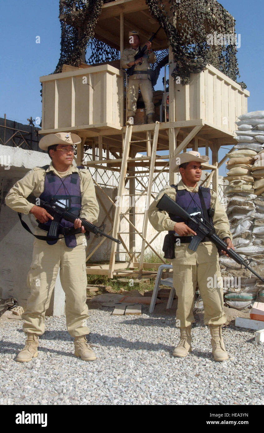 Gurkha military members Mr. Tej Bahadur (left), Mr. Chitra Bahadur Chhetri (right) and Mr. Gopal Gurung on the tower, patrol the compounds of the Coalition Provision Authority (CPA) in Baghdad Iraq.  The Gurkhas are from the islands of Nepal, and are serving in the liberation of Iraq during Operation IRAQI FREEDOM. Stock Photo