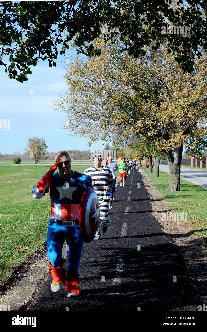 A runner dressed as Captain America salutes while running during the Halloween costume fun run Oct. 28, 2014 at Scott Air Force Base, Ill. Runners dressed as a variety of characters from literature, film, television and video games. Staff Sgt. Jonathan Fowler) Stock Photo