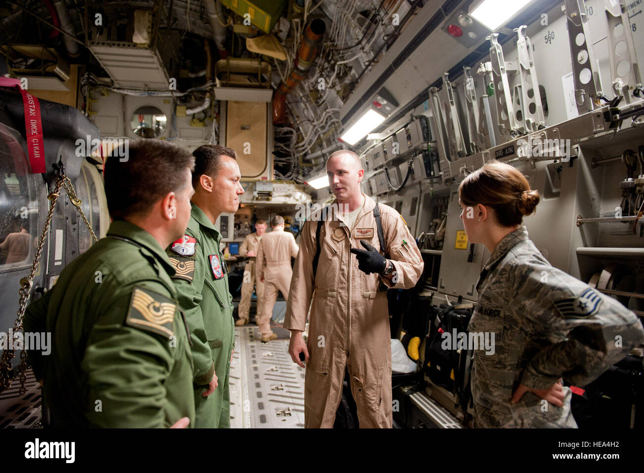 Staff Sgt. Micah Hackett, 6th Airlift Squadron loadmaster, second from right, gives a safety briefing to two Turkish air force UH-60 Black Hawk helicopter pilots, left, and Staff Sgt. Lana Mills, 39th Air Base Wing Public Affairs broadcaster, right, on a C-17 Globemaster III May 3, 2012, at Incirlik Air Base, Turkey. The C-17 aircrew from Joint Base McGuire-Dix-Lakehurst, N.J., transported a Turkish air force helicopter to Kabul, Afghanistan, May 5, 2012. The joint support mission provided smooth delivery of the helicopter to replace one that crashed December 2011. Stock Photo