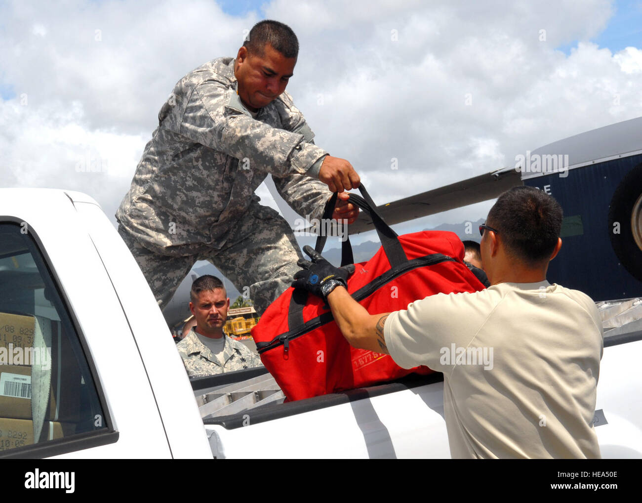 Sgt. Richard Tabula from the Hawaii National Guard's Chemical Biological Radiological Nuclear, or high-yield explosive Enhanced Response Force Package and Staff Sgt. Nathan Angel from the 15th Logistics Readiness Squadron , unloading a pickup truck, in support of humanitarian effort to American Samoa, on 30 September 2009, at Hickam Air Force Base, Hawaii.  The humanitarian support provided aid for the island nation, which was struck by an earthquake and tsunami Sept. 29. Stock Photo