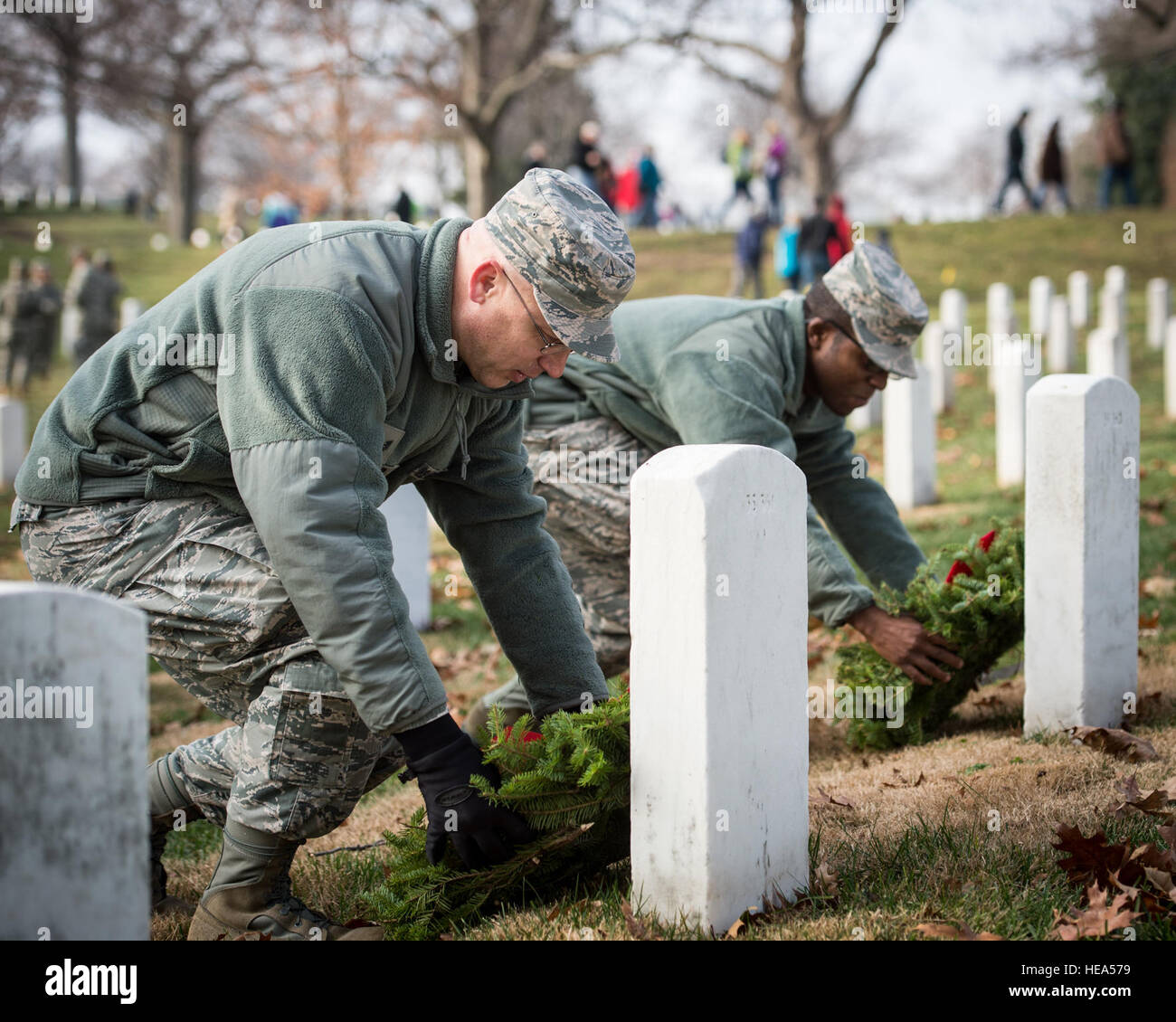 Tech. Sgt. Richy Kruger and Senior Airman James Arredon, Airmen assigned to Air Force Mortuary Affairs Operations at Dover Air Force Base, Delaware, place holiday wreaths on two graves at Arlington National Cemetery, Dec. 13, 2014. Both Kruger and Arredon said that volunteering to honor the fallen at Arlington was a natural extension of their duties at AFMAO.  Captain Raymond Geoffroy Stock Photo