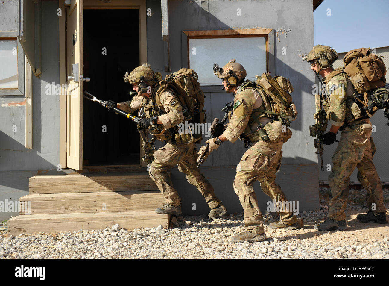 BAGRAM AIRFIELD, Afghanistan – U.S. Air Force Senior Airman Joseph Brady (left), Staff Sgt. Jason Lee (center), and Senior Airman Thomas Schalin breach a door and prepare to clear a room during a mission rehearsal in an excess structure here Aug. 26, 2014. The event allowed pararescuemen from the 83rd Expeditionary Rescue Squadron, to hone their breaching, clearing, patient care, and egress skills. Air Force rescue forces conduct combat search and rescue and personnel recovery operations. Brady and Schalin are deployed from Davis-Monthan AFB, Ariz., and Lee is an Air National Guardsmen deploye Stock Photo