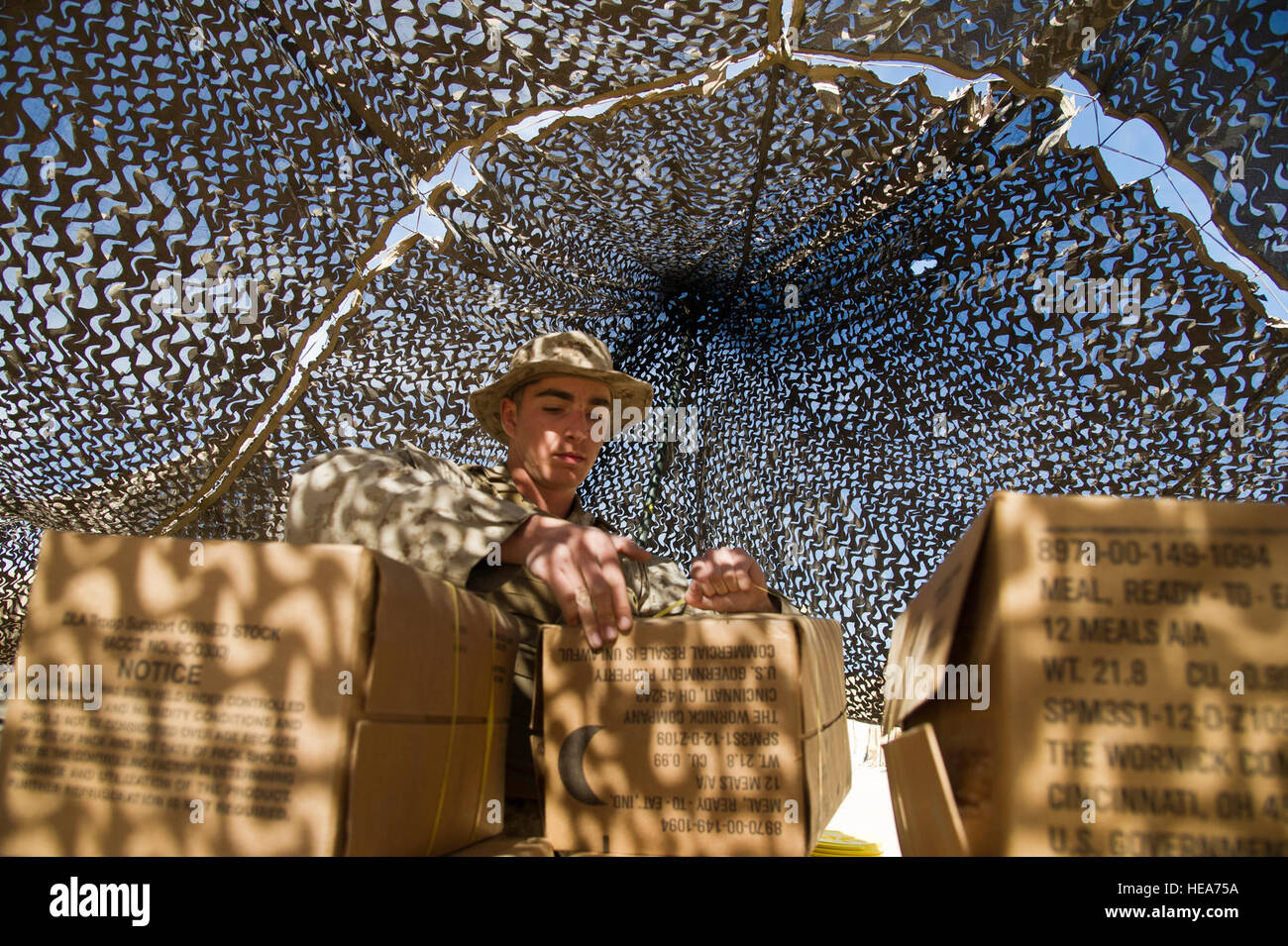 U.S. Marine Lance Cpl. John Yager, a motor transport mechanic assigned to Headquarters and Service Battalion, 1st Marine Logistics Group, Marine Corps Base Camp Pendleton, Calif., unpacks a box of Meals, Ready-to-Eat during Integrated Training Exercise 2-15 at Marine Corps Air Ground Combat Center (MCAGCC) Twentynine Palms, Calif., Feb. 11, 2015. MCAGCC conducts relevant live-fire combined arms training, urban operations, and joint/coalition level integration training that promote operational forces' readiness.  Tech. Sgt. Efren Lopez Stock Photo