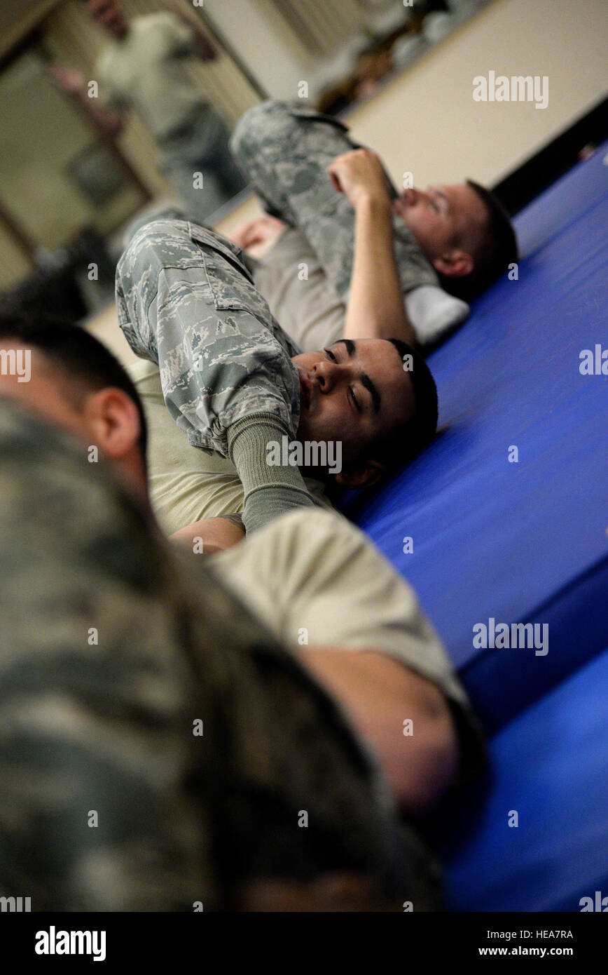 Senior Airman Abraham Mercado, 47th Security Forces Squadron combat arms instructor, submits to an 'arm bar' in Losano Fitness Center on Laughlin Air Force Base, Texas, July 10, 2015. The United States Air Force has at times in its history been at the forefront of combatives training. In 1951, Gen. Curtis Lemay appointed Emilio 'Mel' Bruno, his Judo teacher and a former national American Athletic Union Wrestling champion and fifth degree black belt in Judo, to direct a command-wide Judo and combative measures program.  2nd Lt. Taylor S. Peterson)(Released) Stock Photo