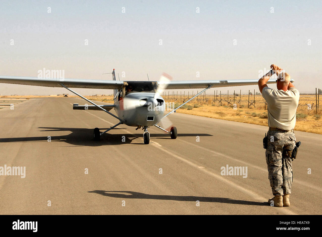 Staff Sgt. Kevin Bremmer marshals a Cessna 172 July 13 at Kirkuk Regional Air Base, Iraq.  The aircraft was flown by 2nd Lt. 'Joseph,' an Iraqi air force student pilot, and Capt. Jamie Riddle, a 52nd Expeditionary Flying Training Squadron instructor pilot. The pilots surpassed 2,000 flight training hours, marking a milestone for the Iraqi air force.  Sergeant Bremmer is deployed to the 52nd EFTS from McGuire Air Force Base, N.J., and Captain Riddle is deployed from Columbus AFB, Miss.  Airman First Class Randi Flaugh) Stock Photo