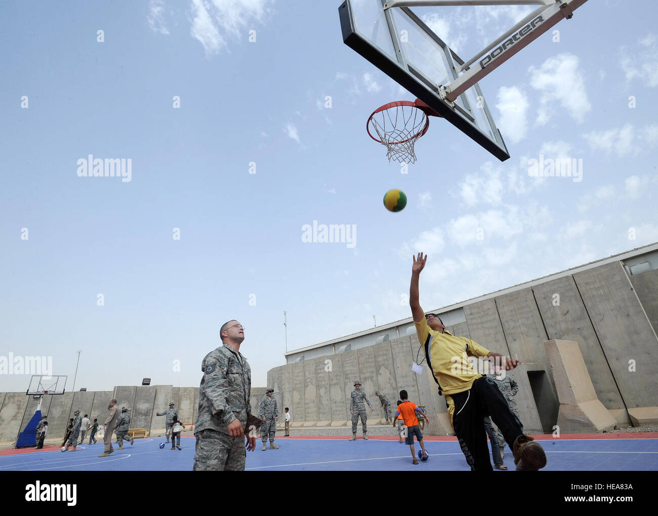 Technical Sgt. Coda Whitehead, 332nd Expeditionary Maintenance Squadron, plays basketball with an Iraqi boy during Iraqi Kids Day at Joint Base Balad, Iraq, June 19. Whitehead volunteered as a mentor for the event. Iraqi Kids Day serves as part of the ongoing base effort to spread goodwill to the local community. Over 70 children from local villages were bussed on base to play games, share culture and to have a day of fun. : Senior Airman Matthew Coleman-Foster) Stock Photo