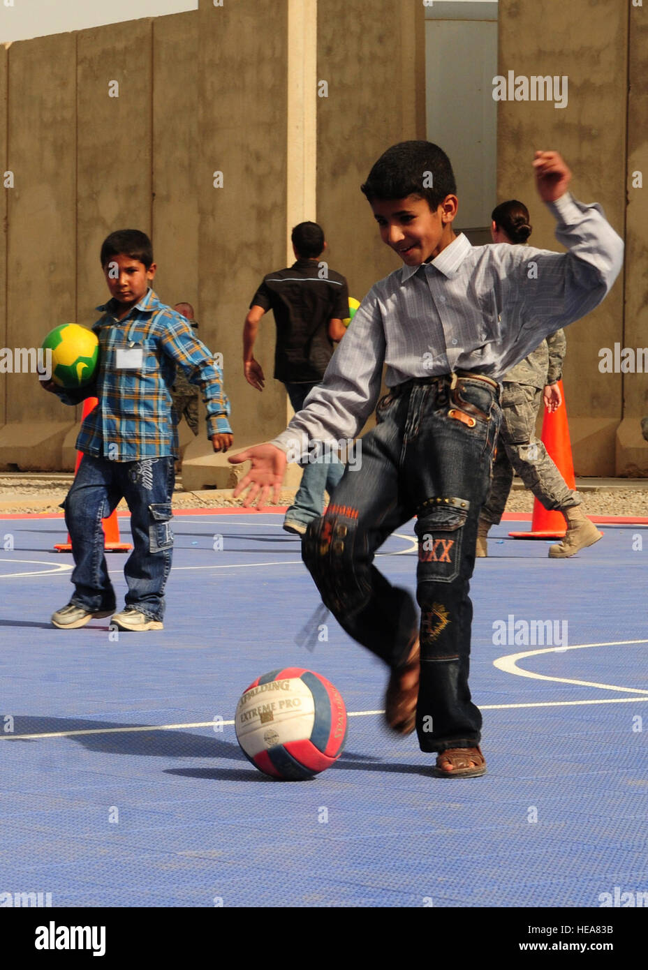 JOINT BASE BALAD, Iraq -- An Iraqi child kicks a soccer ball in an effort to score a goal during the Iraqi Kids Day here Oct. 10, 2009. JBB hosted 125 children, parents and officials, increasing community relations with surrounding villages.  Staff Sgt. Heather M. Norris) (Released) Stock Photo