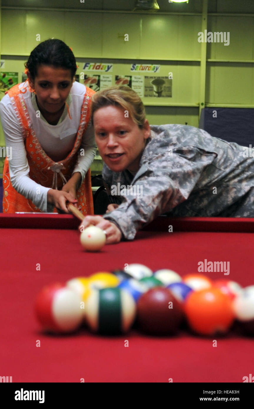 Army Col. Colleen Shull, 502nd Dental Company Area Support officer in charge, plays a game of billiards with some local children during Iraqi Kids Day at Joint Base Balad, Iraq, April 24. This was the first Iraqi Kids Day of 2010 and it serves as part of the ongoing base effort to positively engage the local populace. Thirty-four children from a local orphanage were bussed on base to play games, share culture and to have a day of fun. Stock Photo