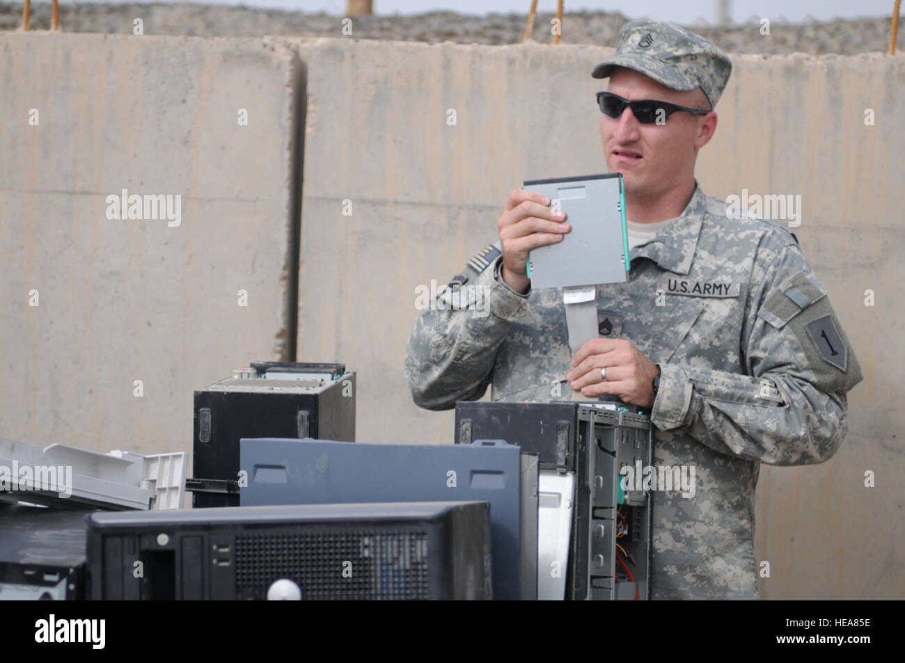 U.S. Army Staff Sgt. Joshua Weinland from the 1st Infantry Division, 5-2 Federal Police Training Team, removes a disk drive from a computer at the Defense Reutilization and Marketing Service area, at Camp Victory, near Baghdad, Iraq, Oct. 30. Stock Photo
