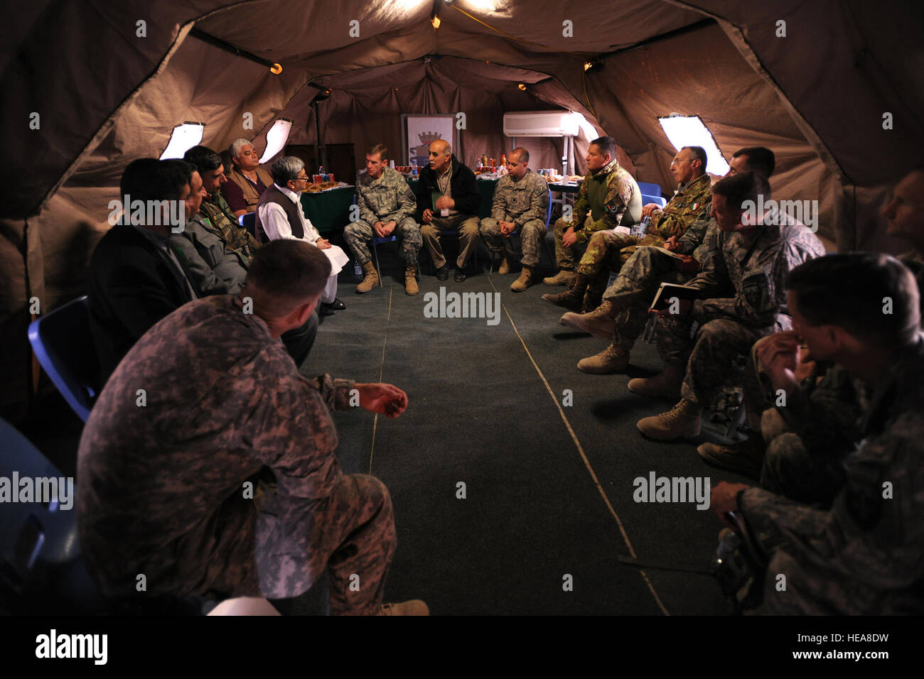 In a tent located on Forward Operating Base (FOB) Farah, Gen. Stanley McChrystal, the International Security Assistance Force (ISAF) Commander, meets with Farah Province government officials and coalition leaders, Jan. 22, 2010. Among the military leaders present was the Regional Command West (RC-West) Commander, Italian Brig. Gen. Alessandro Veltri, the Italian Task Force South Commander, Col. Massimo Raccanpo, the Farah Provincial Reconstruction Team Commander, U.S. Navy Cmdr. Lawrence Vasquez, the 4-73rd Cavalry Battalion Commander, U.S. Army Lt. Col. Michael Wawrzyniak, and U.S. Marine Cor Stock Photo