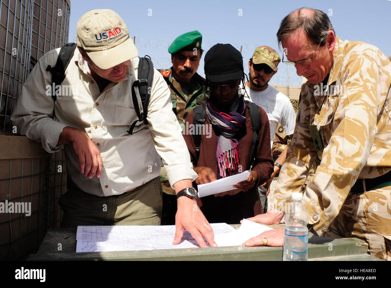 ISAF Deputy Commander, British Lt. Gen. Nick Parker, right, is shown a map of future reconstruction projects in Farah Province by Ben Kauffeld, left, and Marsha Michel, United States Agency for International Development (USAID) Field Program Officers of the Farah Provincial Reconstruction Team, in Farah Province, April 7, 2010.  Gen. Parker met with Afghan, Italian and American forces during his two-day visit to the Farah Province, in addition to attending a shura with Government of the Islamic Republic of Afghanistan officials in the village of Qa Ryeh Sirak.    (ISAF  U.S. Air Force Senior A Stock Photo