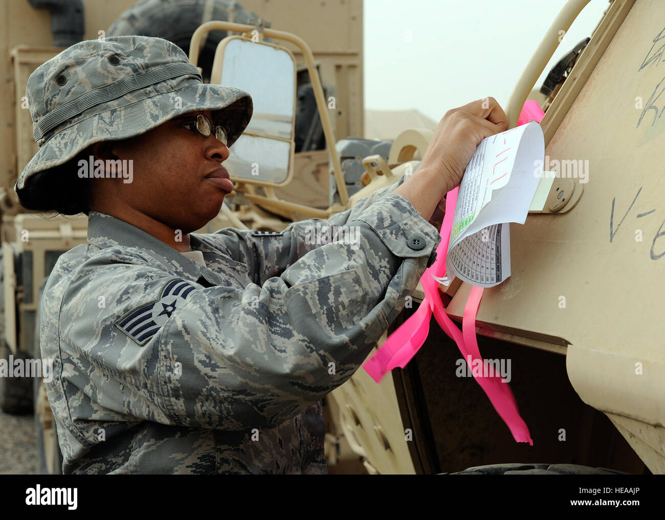 Staff Sgt. Chayla Gooch, 732nd Expeditionary Logistical Readiness Squadron, 586th Task Force, marks the armored security vehicle ensuring the right vehicles get picked up for transport at Camp Liberty, Iraq on Feb. 27, 2009. This vehicle is a part of a convoy going to Kuwait with approximately 30 semi trucks loaded with all types of military vehicles. Sergeant Gooch is a Joint Expeditionary Taking airman who is an Air Force member tasked for army jobs.  The personnel at the yard have processed more than a billion dollars of inventory for the Army through their six month deployment. Sergeant Go Stock Photo