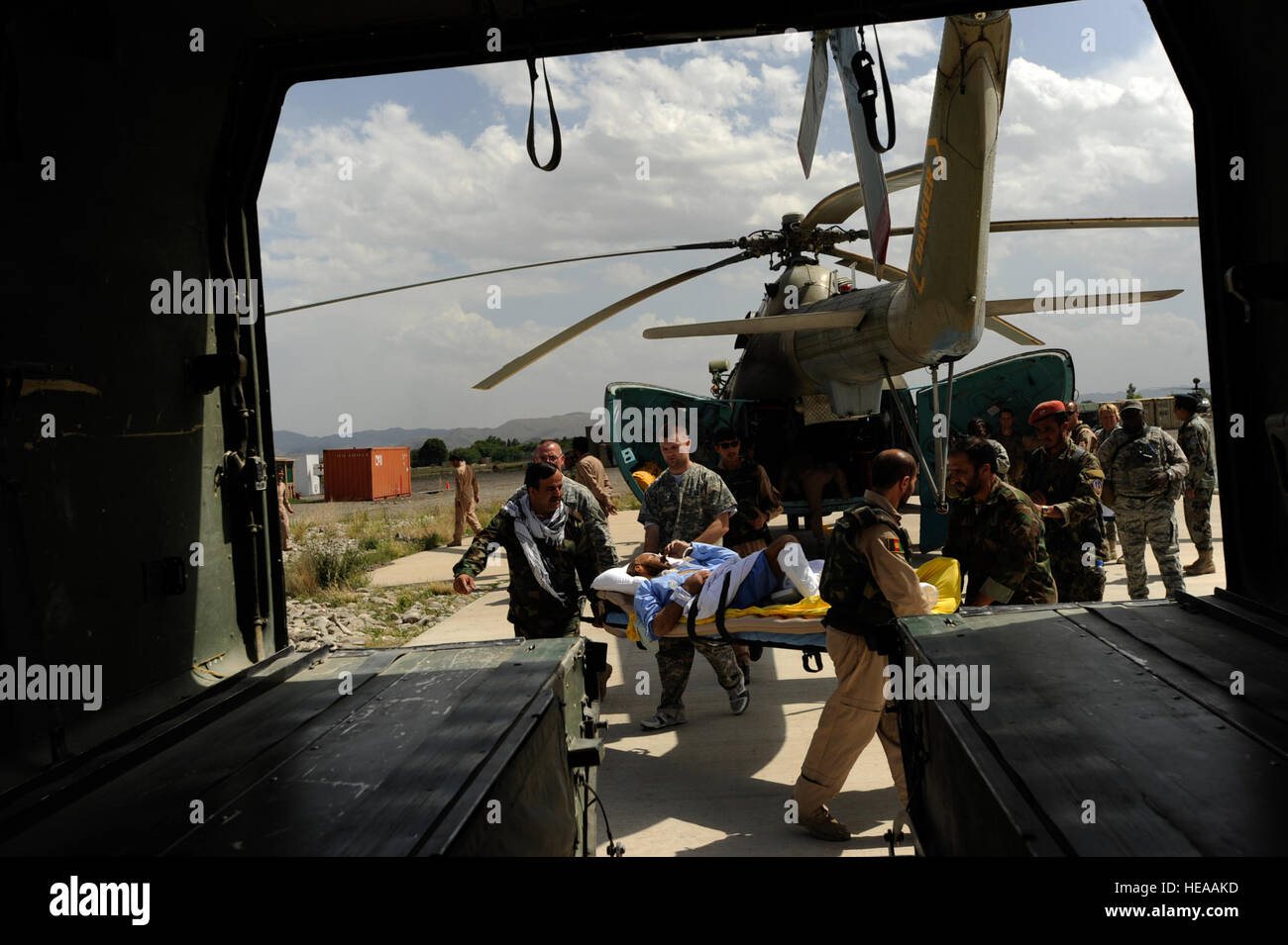 Afghan national army air corps soldiers and flight medics carry a patient from an Mi-17 helicopter to an ambulance for transport to the Salerno Hospital, May 12, at Forward Operating Base Salerno, Afghanistan. Stock Photo