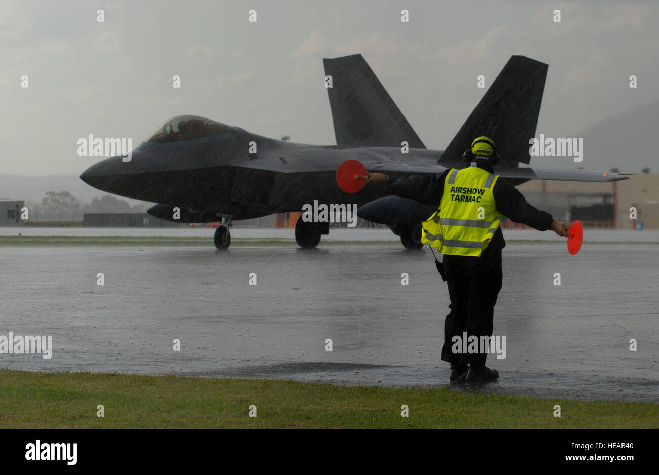 Lyn Jones, Aircraft Ground Operation Aviation Services section leader blue, marshalls an F-22 Raptor assigned to the 154th Wing at Joint Base Pearl Harbor-Hickam, Hawaii, at Avalon Airport, Victoria, Australia, Feb. 22, 2015. The U.S. participates in the Australian International Airshow and other similar events to demonstrate the U.S. focus on regional security and stability and support the rebalance to the Asia-Pacific region. Staff Sgt. Sheila deVera) Stock Photo