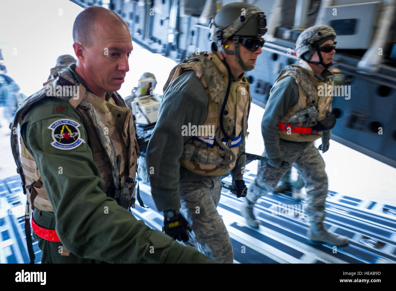 U.S. Air Force Maj. Carl Impastato, flight nurse, 43rd Aeromedical Evacuation Squadron, Pope Army Airfield, N.C., guides Airmen carrying a simulated patient on a litter aboard a C-17 Globemaster III at Joint Readiness Training Center (JRTC), Fort Polk, La., Jan. 17, 2014. Service members at JRTC 14-03 are educated in combat patient care and aeromedical evacuation in a simulated combat environment.  Master Sgt. John R. Nimmo, Sr./) Stock Photo