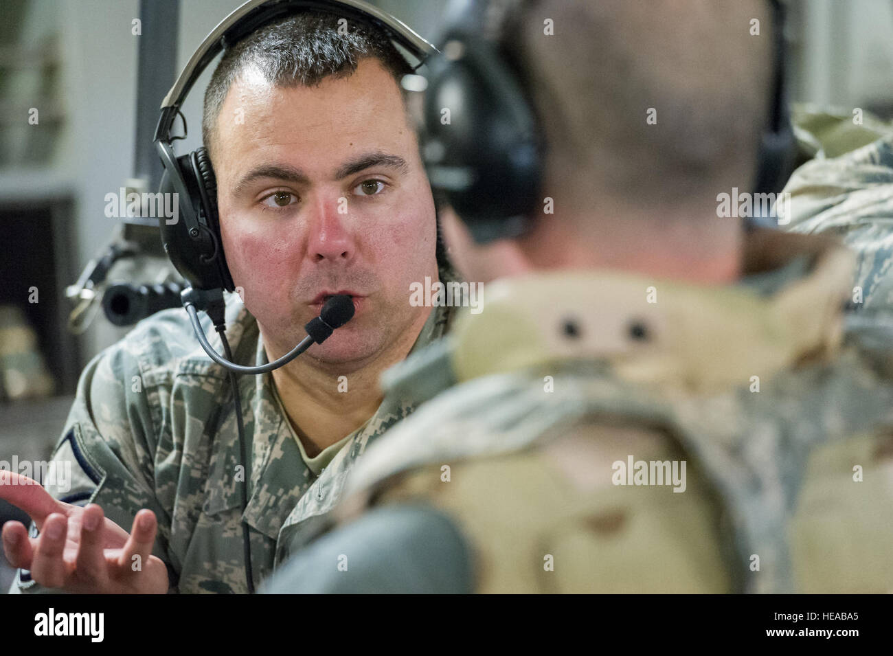 U.S. Air Force Master Sgt. James Woods, respiratory therapist, 711th Human Performance Wing, Wright-Patterson Air Force Base, Ohio, discusses patient care with a fellow team member while in-flight aboard a C-17 Globemaster III at Joint Readiness Training Center (JRTC), Fort Polk, La., Jan 17, 2014. Service members at JRTC 14-03 are educated in combat patient care and aeromedical evacuation in a simulated combat environment.  Master Sgt. John R. Nimmo, Sr./) Stock Photo