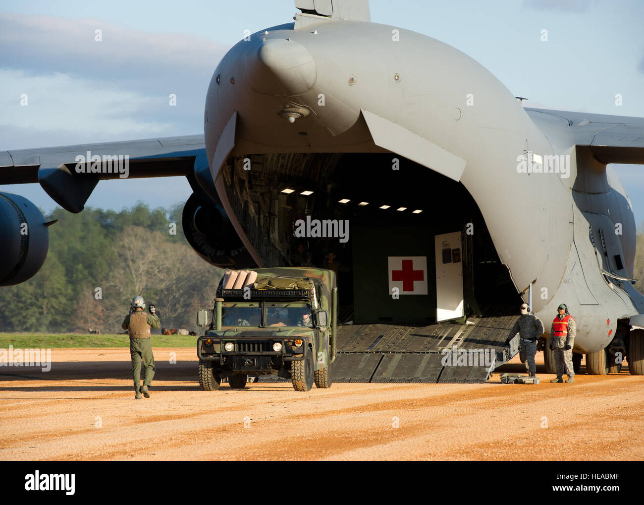 A humvee backs into a U.S. Air Force C-17 Globemaster III during a field exercise at the Joint Readiness Training Center (JRTC), Fort Polk, La., March 17, 2014. Service members at JRTC 14-05 are educated in combat patient care and aeromedical evacuation in a simulated combat environment.  Staff Sgt Joseph Araiza Stock Photo