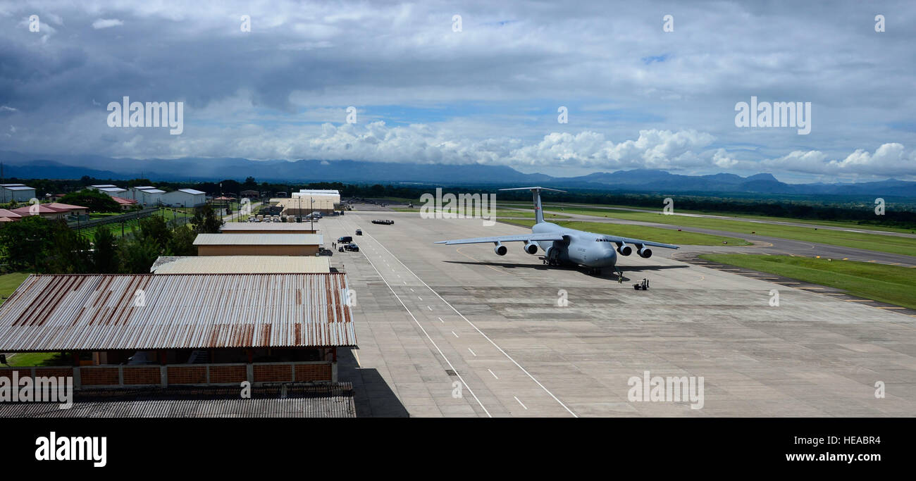 Crew members of a C-5 Galaxy from Westover Air Reserve Base, Mass., prepare to unload their cargo of donated goods at Soto Cano Air Base, Honduras, Oct. 11, 2014.  The cargo transporting aircraft delivered over 6,000-pounds of humanitarian aid and supplies that were donated to Honduran citizens in need through the Denton Program.  The Denton Program allows private U.S. citizens and organizations to use space available on U.S. military cargo planes to transport humanitarian goods to approved countries in need.  Tech. Sgt. Heather Redman) Stock Photo