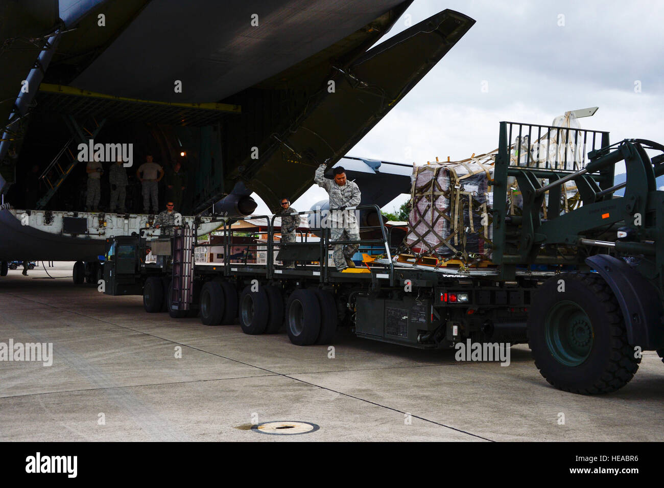Crew members of a C-5 Galaxy from Westover Air Reserve Base, Mass., and members from the 612th Air Base Squadron unload a shipment of donated goods at Soto Cano Air Base, Honduras, Oct. 11, 2014.  The cargo transporting aircraft delivered over 6,000-pounds of humanitarian aid and supplies that were donated to Honduran citizens in need through the Denton Program.  The Denton Program allows private U.S. citizens and organizations to use space available on U.S. military cargo planes to transport humanitarian goods to approved countries in need. Tech. Sgt. Heather Redman) Stock Photo