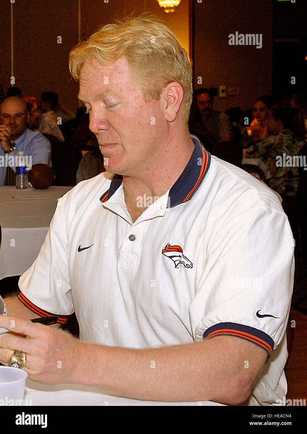 Former Denver Broncos captain and All-Pro Karl Mecklenburg signs the football of Mitchell Flack, a young Air Force dependent and flag football player, the son of TSgt Harry Metheny and his wife Debra.  Mr. Mecklenberg rose from being a college walk-on and a 12th round draft pick to a pro career that included six Pro Bowl and three Super Bowl appearances. He was the guest of honor at the 21st Services Squadrons 2007 Flag Football awards ceremony. Stock Photo