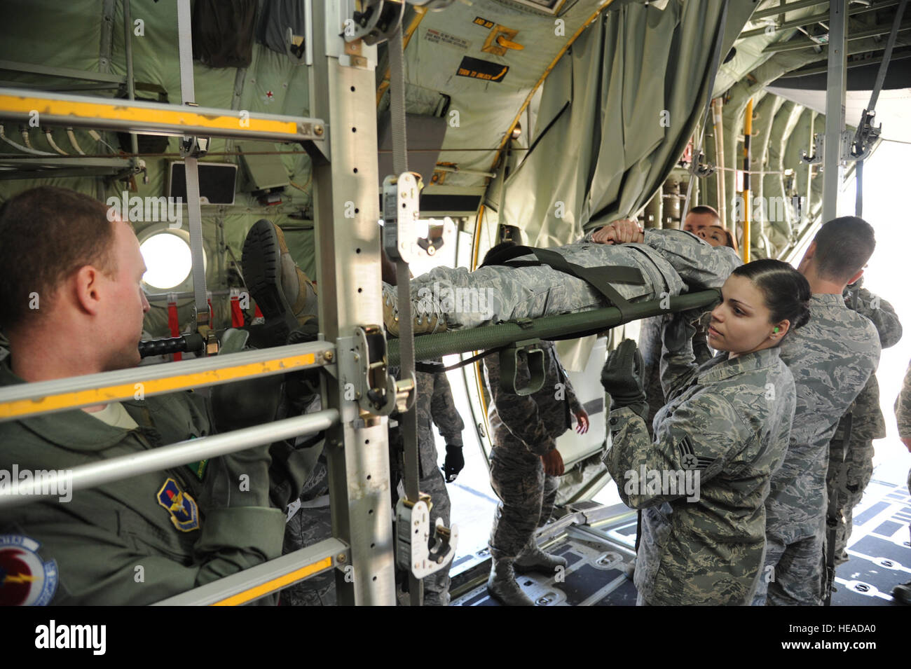 U.S. Air Force Senior Airman Ashley Figueroa, right foreground, with the 81st Aerospace Medicine Squadron (AMDS), helps other members of the 81st Medical Group members as they secure Lt. Col. Mikelle Maddox, a physician with the 81st AMDS role-playing as a patient, aboard a C-130 Hercules aircraft during air evacuation training March 14, 2013, at Keesler Air Force Base, Miss. The training was intended to provide experience in configuring C-130s for patient transport. Airmen with the 81st MDG, 81st AMDS, 81st Medical Operations Squadron and 53rd Weather Reconnaissance Squadron took part in the  Stock Photo