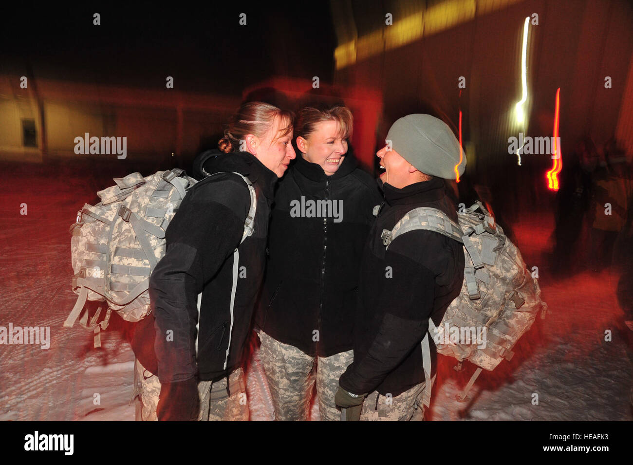 Colorado Army National Guard Staff Sgt. Laura VanGilder (center) greets two of her friends returning from Iraq at the JetCenter in Colorado Springs, Colo., Dec. 17. Sgt. 1st Class Kristy Schwarts (left) and Sgt. 1st Class Denise Drummond (right) of the 220th Military Police Company, Colorado Army National Guard, left for pre-deployment training last January. While deployed, the 220th MP Company was assigned to Task Force 134 at Camp Cropper in Baghdad, where Soldiers were responsible for detainee operations; ensuring the care and safeguarding of detainees in conjunction with the Government of  Stock Photo