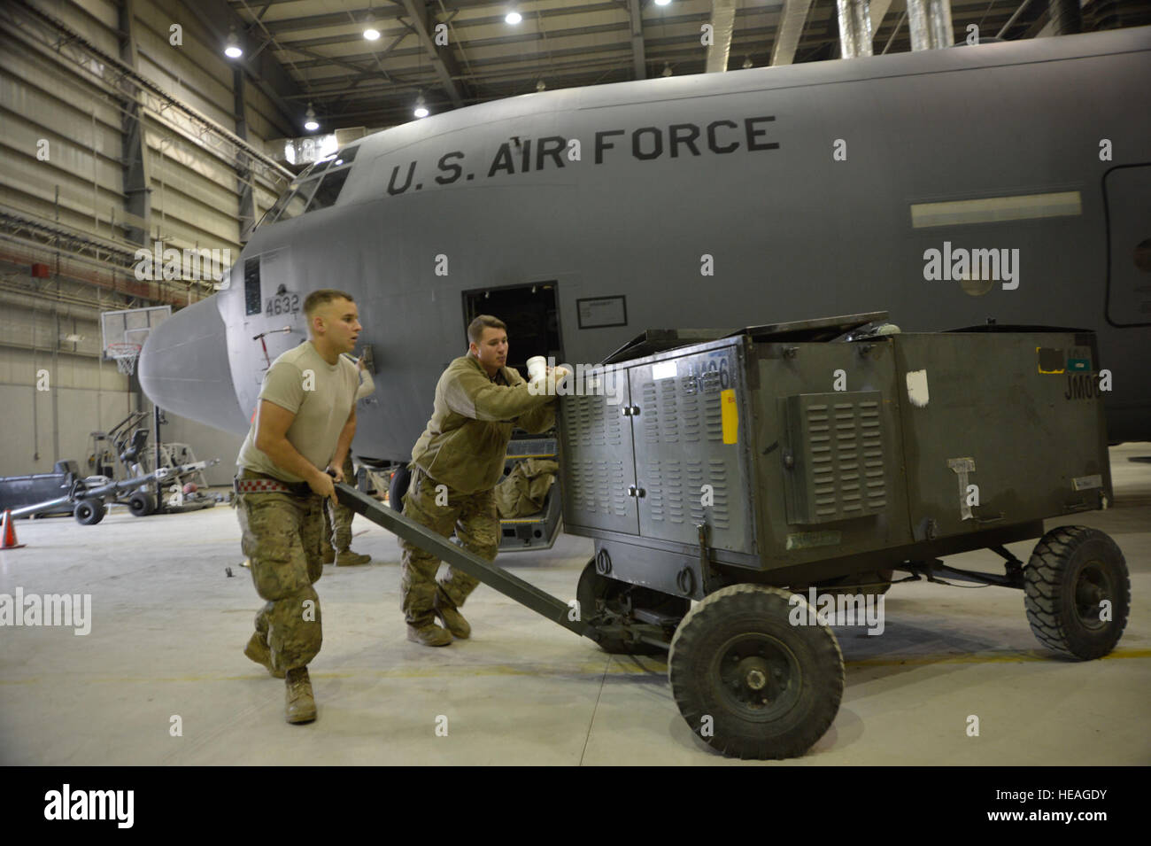 U.S. Air Force Senior Airman Charles Livesoy and Staff Sgt. Ian Farley move a generator that will be used in conjunction with jacks to raise a C-130J Super Hercules Nov. 3, 2014. Livesoy and Farley are crew chiefs assigned to the 19th Aircraft Maintenance Squadron at Little Rock Air Force Base, Ark. They are responsible for ensuring C-130J aircraft are mission ready to provide airlift and cargo movements throughout Afghanistan. Livesoy is a native of St. Louis, Mo. and Farely is from Auburn, Calif.  Master Sgt. Cohen A. Young Stock Photo