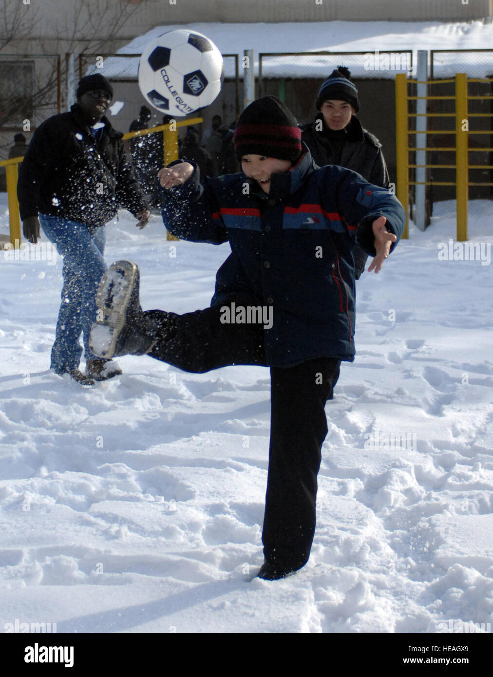 A young boy shows off his soccer skills to Staff Sgt. Milbert Bourgeois and another friend at the Belovodsk, or Belovodosky orphanage, north of Bishkek, Kyrgyzstan.  Airmen from nearby Manas Air Base visit the orphanage frequently to share friendship and donated toys as well as clothing, blankets, diapers and toiletries. There are more than 265 disabled children in the orphanage between the ages of 4 and 18. Sergeant Bourgeois is a Nevada Air National Guardsman who is deployed with the 376th Expeditionary Security Forces Squadron. Tech. Sgt. Phyllis Hanson) Stock Photo