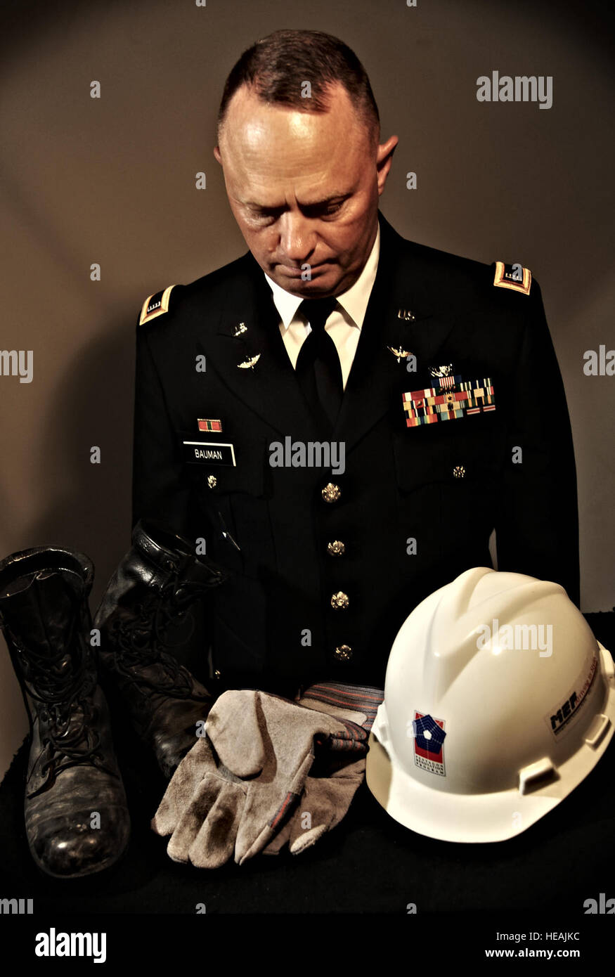 U.S. Army National Guard Chief Warrant Officer 4 Clifford Bauman, while at Langley Air Force Base, Va., Aug. 22, 2013, reflects on the boots, gloves and hat he wore during search and rescue missions at the Pentagon, Washington, D.C., after the Sept. 11, 2001 attacks. After the missions were over, Bauman placed the work gear in closet and did not touch them again until 12 years later. (U.S.  illustration by Staff Sgt. Jarad A. Denton Stock Photo