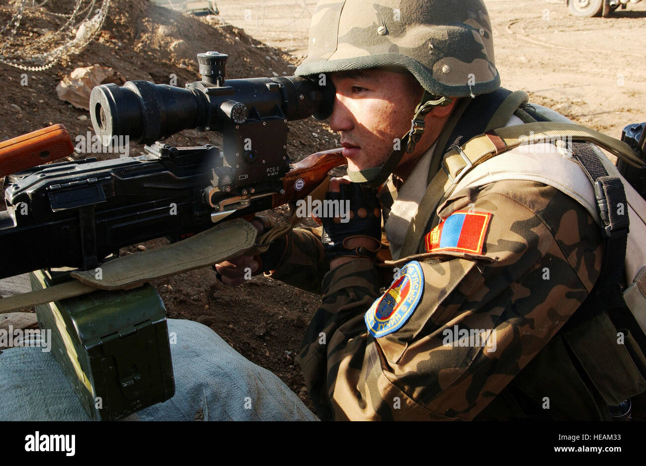 A Mongolian Quick Reactionary Force (QRF) Army Soldier scans the area with his AKMS 7.62 Rifle utilizing a bunker for cover, ready to defend Camp Echo from possible threats Dec 8, 2006. The Mongolian Contingency is responsible for internal security for Camp Echo, protecting the lives of 11 nations.  Tech. Sgt. Dawn M. Price)(released) Stock Photo