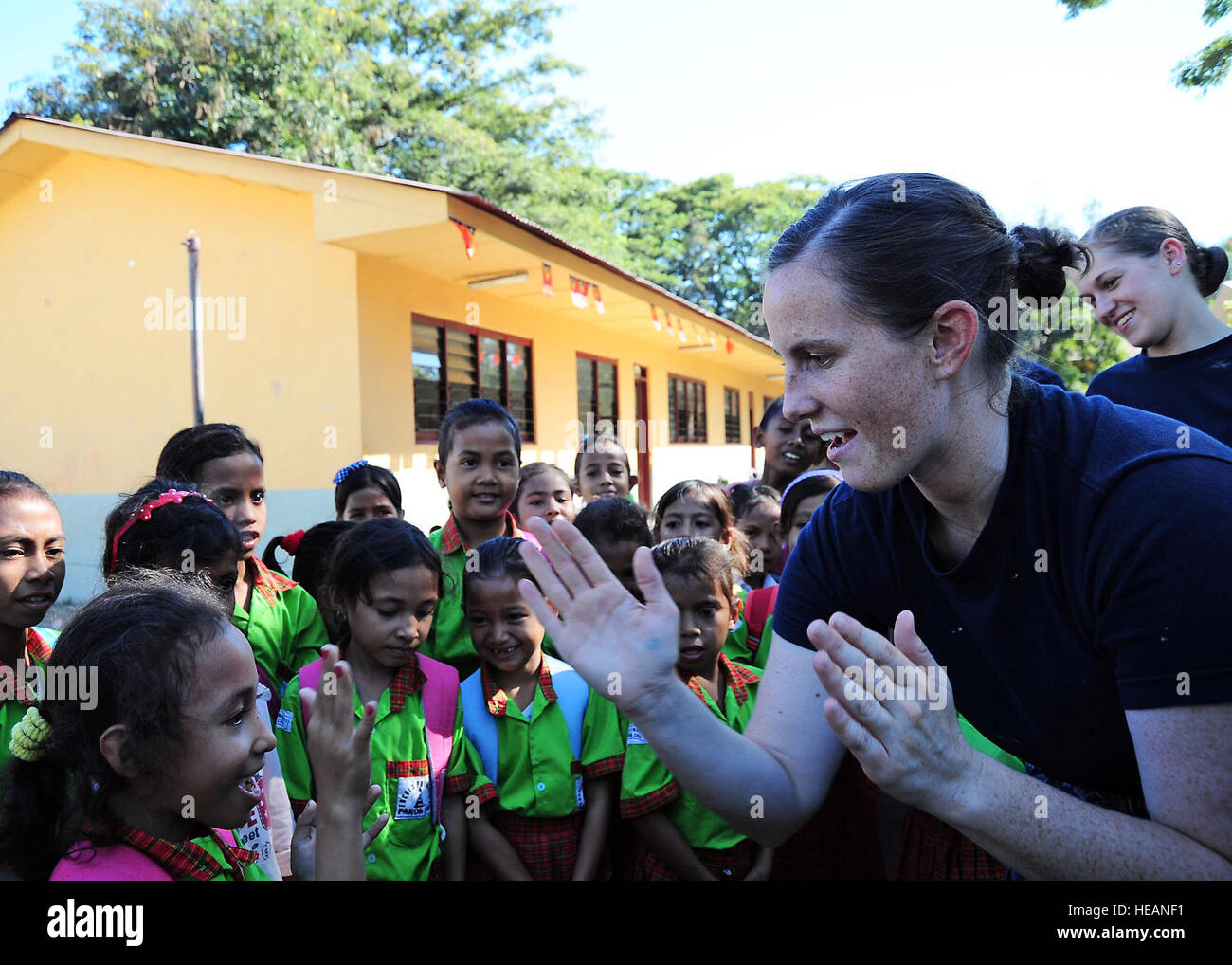 Ensign Allison Luzwick claps hands with a Timorese girl at Farol Primary School during a community service event for the Timor-Leste phase of Pacific Partnership 2011. Pacific Partnership is a five-month humanitarian assistance initiative that will make port visits to Tonga, Vanuatu, Papua New Guinea, Timor-Leste and the Federated States of Micronesia. Also pictured is Petty Officer 2nd Class Victoria Kent.  Tech. Sgt. Tony Tolley) Stock Photo