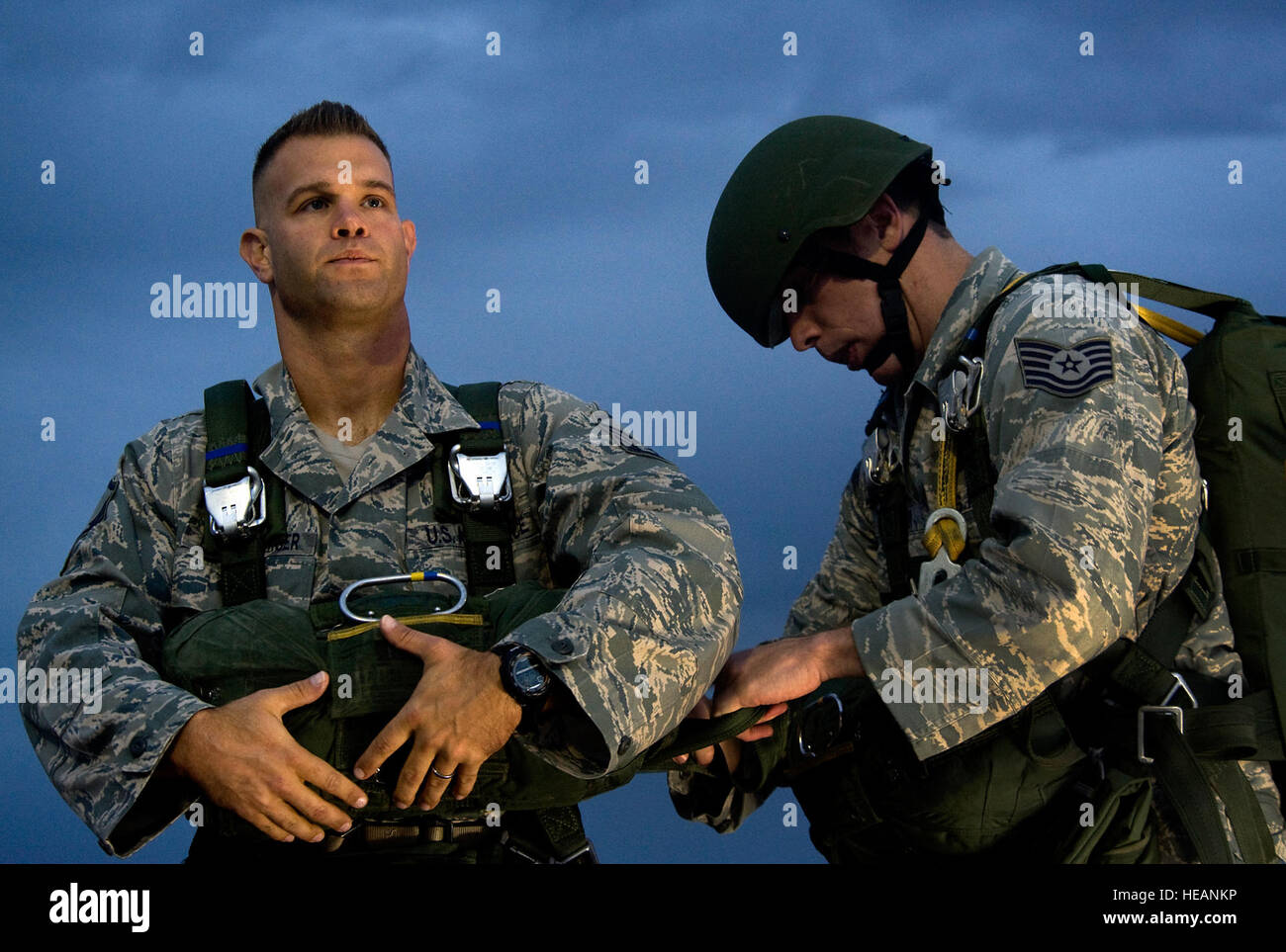 From left, U.S. Air Force Master Sgt. Guenther Bogensperger, 820th RED HORSE Airborne flight airborne water and fuels systems maintenance superintendent, receives  a Jumpmaster Pre-inspection from Tech Sgt. James Spreter, 6th Combat Training Squadron joint terminal attack controller instructor, prepare to board a C-130 Hercules during a jump mission Oct. 4, 2011, at Nellis Air force Base, Nev. RED HORSE and 6 CTS Airmen perform airdrop mission to stay current on training and certifications, enabling them to perform jump missions and operate their own drop zones.  Staff Sgt. Christopher Hubenth Stock Photo