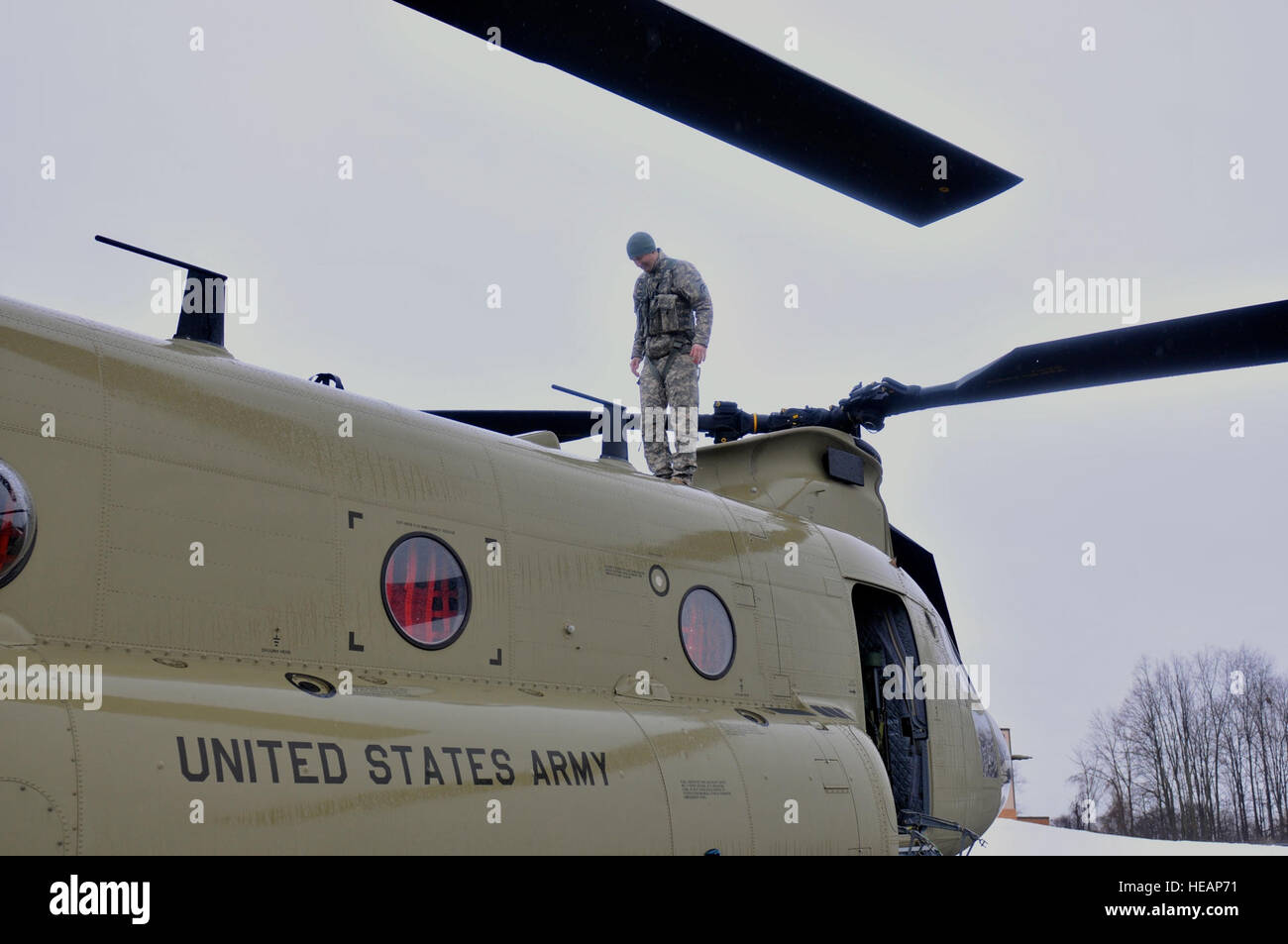 Army Staff Sgt. Mike Landaur completes a safety check of a CH-47F Chinook helicopter March 14, 2015. Staff Sgt. Landaur is a CH-47F crew chief from Company B, 3rd Battalion, 126th Aviation based at the Army Aviation Support Facility at Rochester International Airport. Thirty Airmen from the 274th Air Support Operations Squadron (ASOS), based at Hancock Field Air National Guard Base, and the Army aircrew trained together for the first time. The training included Joint Terminal Attack Controller (or JTAC) Airmen from the 274th ASOS conducting CH-47 helicopter familiarization training, safety bri Stock Photo