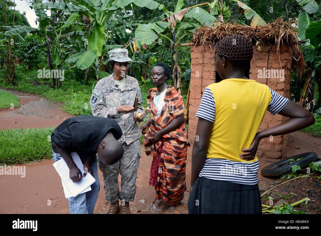 U.S. Army Maj. Daisy Wilson, a public health nurse with the 411th Civil Affairs Battalion, Combined Joint Task Force-Horn of Africa, pulls key health assessment information from community leader Nalubwma Vincent and family as Ugandan veterinarian Dr. Douglas Kibuuka, Bombo, records findings during a site survey of dozens of homes in the remote village of Kakute, site of the world's last Ebola breakout in November. The human and animal health care team is part of One Health, a two-week whole-of-government program that strengthens Uganda's healthcare and counterbioterrorism capabilities and reco Stock Photo