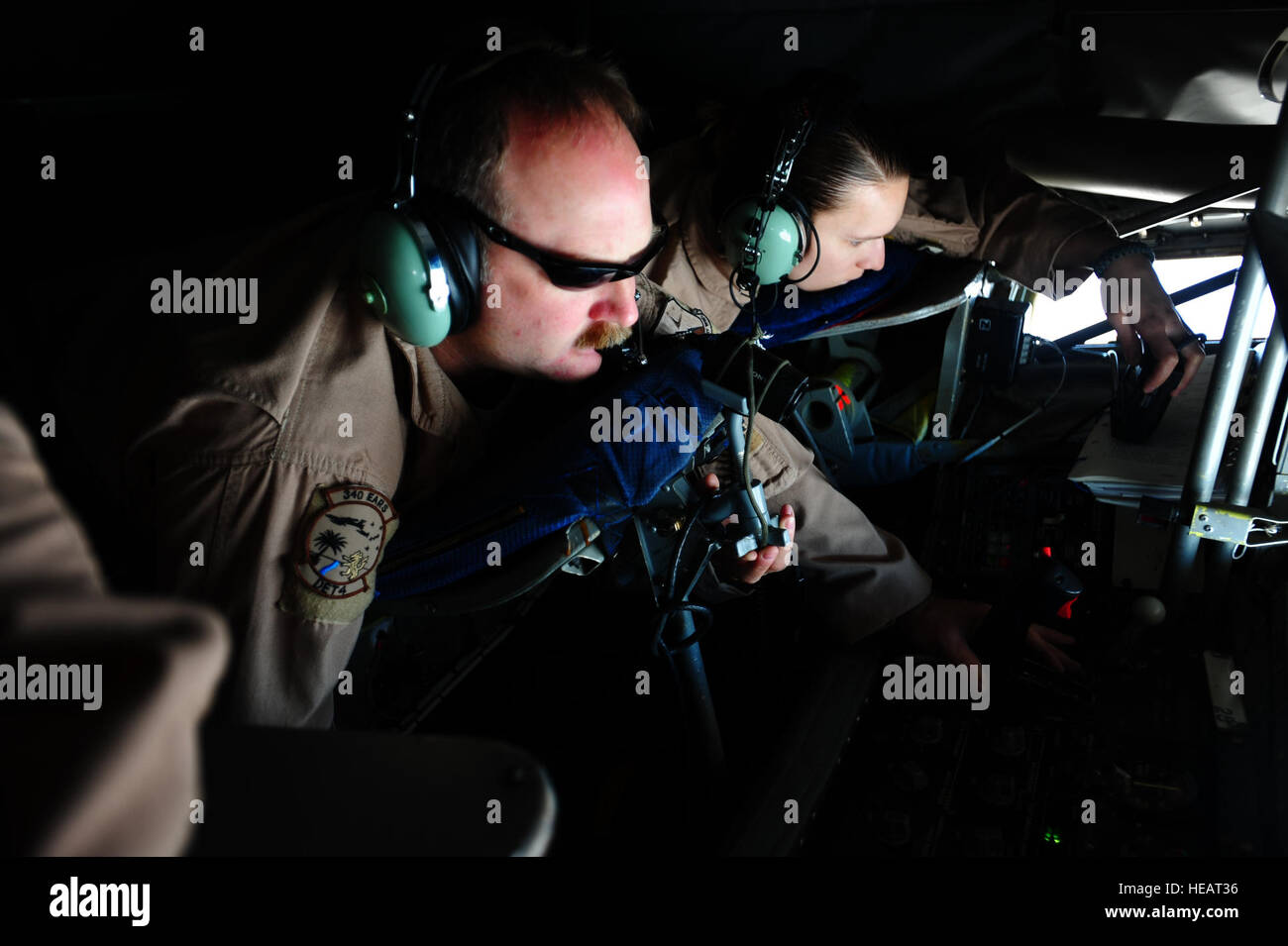 Master Sgt. John Austin, 340th Expeditionary Air Refueling Squadron boom operator, conducts aerial refueling operations while Staff Sgt. Amanda Helton, 1st Combat Camera Squadron aerial combat videographer, documents the mission from a KC-135 Stratotanker supporting Operation Enduring Freedom in the skies above Afghanistan, Feb. 26, 2011. Master Sgt. William Greer) Stock Photo