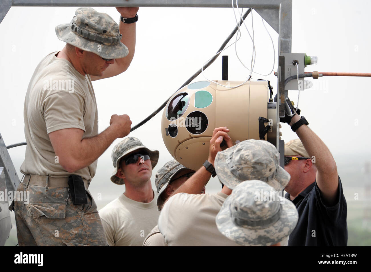 Brian Pollina with Omega Training Group assist U.S. Army soldiers with the 2nd Battalion, 508th Parachute Infantry Regiment, 4th Brigade Combat Team, 82nd Airborne Division assemble the camera body to the 'Raid' system. The Raid is an 80ft surveillance camera system, with capabilities to assist NATO forces in search, surveillance, support and security activities more efficiently at Operations Control Center District, May 5. : Technical Sgt. Joselito Aribuabo) Stock Photo